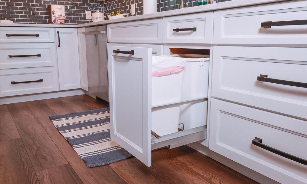 pull out trash can upgrades in a kitchen with white cabinets