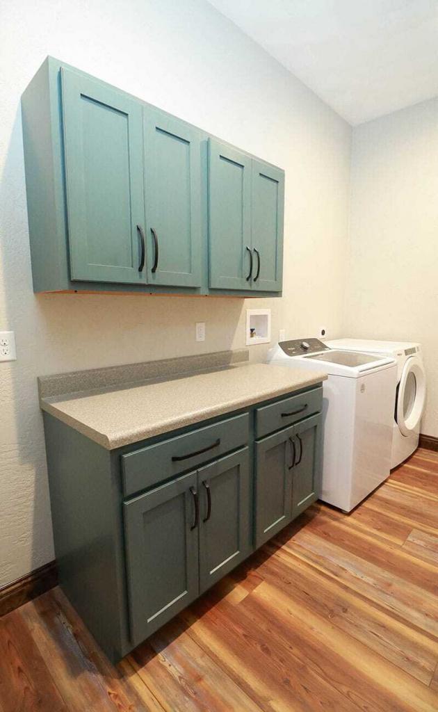 green laundry room cabinets with white counters