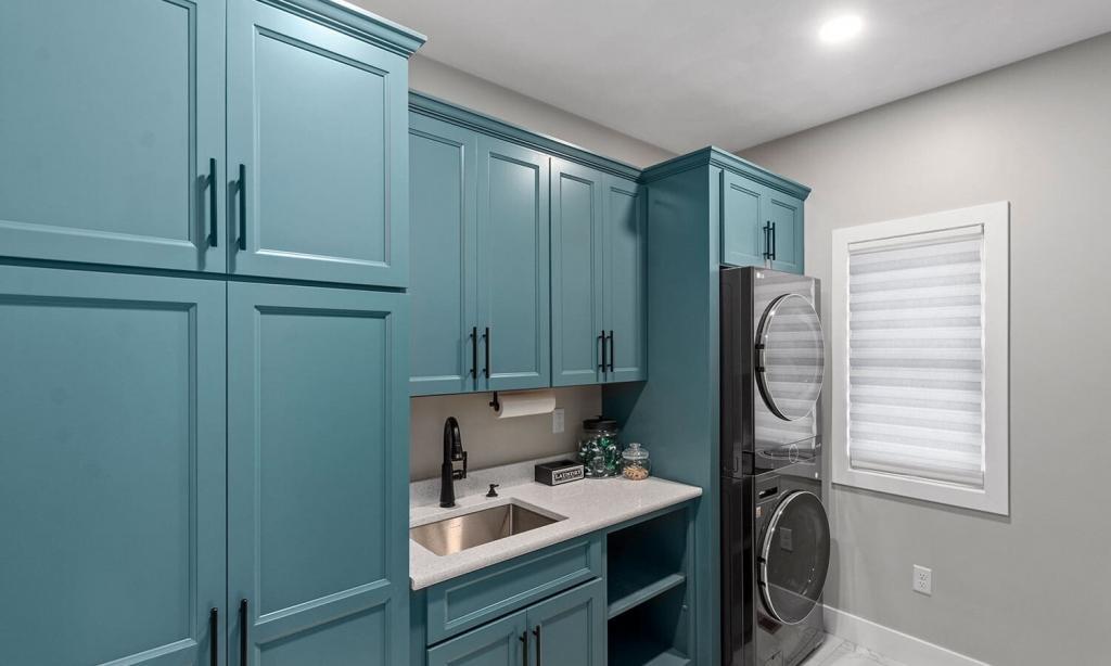modern laundry room with green cabinets